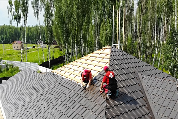 Worker does the installation of the roof of house