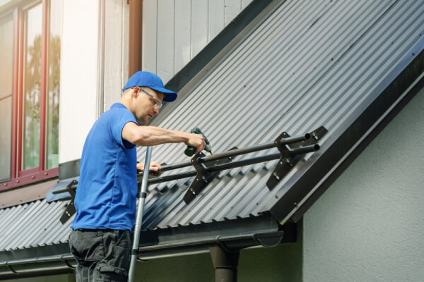 roofer-installing-snow-guard-on-metal-roof